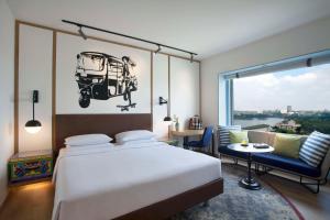 a bedroom with a bed and a table and a window at Hyatt Centric MG Road Bangalore in Bangalore