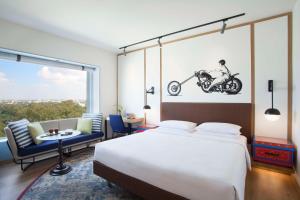 a bedroom with a bed and a motorcycle painting on the wall at Hyatt Centric MG Road Bangalore in Bangalore