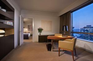 een kamer met een tafel en stoelen en een slaapkamer bij Hyatt Regency Belgrade in Belgrado