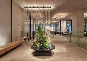 a lobby with a table with a plant in it at Grand Hyatt Melbourne in Melbourne