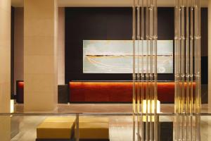 a lobby with two yellow stools and a painting at Grand Hyatt Melbourne in Melbourne