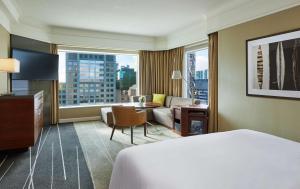 a hotel room with a bed and a living room at Grand Hyatt Melbourne in Melbourne