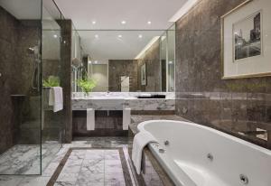 a bathroom with a tub and a shower and a sink at Grand Hyatt Melbourne in Melbourne +70 photos