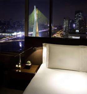 um quarto com uma cama e vista para uma ponte em Grand Hyatt São Paulo em São Paulo