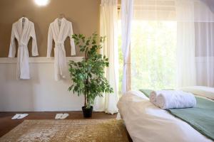 een slaapkamer met witte kleding in een raam bij Quaint Cottage in Graskop