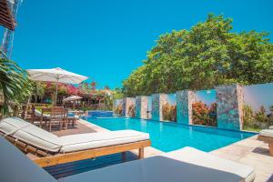 a swimming pool with two chaise lounges at Pousada Carcará in Jericoacoara