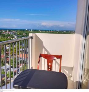 a chair sitting on a balcony with a view of the ocean at Adam&Eva Condo Staycation in Lapu Lapu City