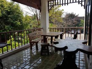 eine Veranda mit Tischen und Bänken auf einem Balkon in der Unterkunft Chiang Mai Homey in Chiang Mai