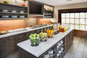 a kitchen with a counter with fruits and vegetables in vases at Hyatt House Boston Waltham in Waltham