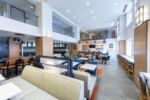 ein Restaurant mit Sofas, Tischen und Stühlen in der Unterkunft Hyatt House Chicago Schaumburg in Schaumburg
