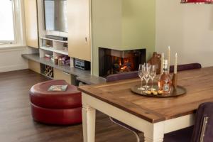 a living room with a table and a fireplace at Heerehuys Lisse in Lisse