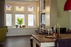 een woonkamer met ramen en een tafel met kaarsen bij Heerehuys Lisse in Lisse