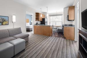 a living room with a couch and a kitchen at Hyatt House Boulder/Broomfield in Broomfield