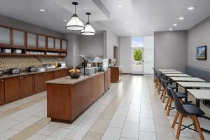 a large kitchen with wooden counters and tables and chairs at Hyatt House Boulder/Broomfield in Broomfield +64 photos