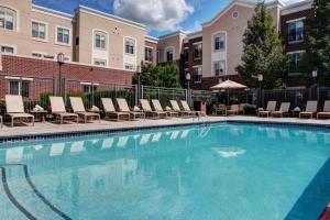 uma piscina com espreguiçadeiras e um edifício em Hyatt House Branchburg - Bridgewater em Branchburg Park