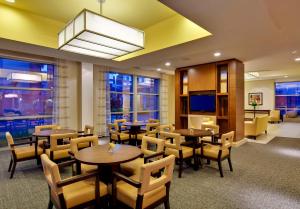 a restaurant with tables and chairs and a television at Hyatt House Fort Lauderdale Airport/Cruise Port in Dania Beach