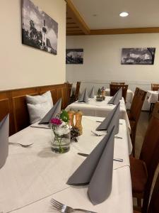ein Esszimmer mit langen Tischen und grauen Servietten in der Unterkunft Hotel Gasthof Zur Post in Königstein in der Oberpfalz