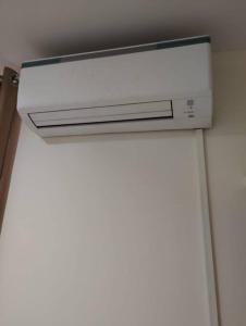 a white air conditioner on the ceiling of a bathroom at Park facing flat for yr comfort in Indore