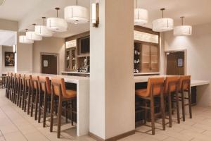 a bar in a restaurant with brown chairs at Hyatt House Emeryville in Emeryville
