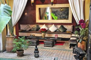 a living room with a couch and a mirror at Riad Aguaviva in Marrakech