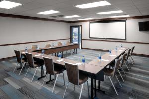 a conference room with tables and chairs and a screen at Hyatt House Scottsdale Old Town in Scottsdale