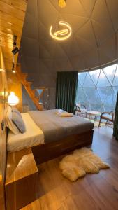 a bedroom with a bed with a staircase and a rug at FAYUL RETREAT - India Highest Glamp and EcoLuxury Stay in Kalpa