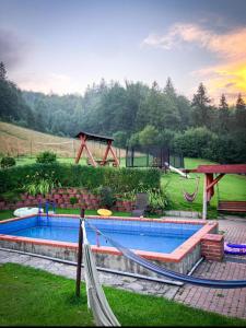 uma piscina com rede de descanso e um parque infantil em Apartamenty Kadłubek em Wisla