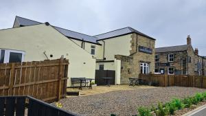 a house with a wooden fence and a patio at Amble Harbour retreats in Amble