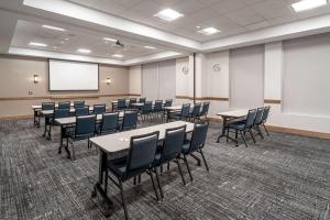 a conference room with tables and chairs and a whiteboard at Hyatt House Salt Lake City Downtown in Salt Lake City