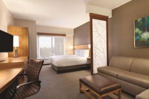 una camera d'albergo con letto e divano di Hyatt Place at Anaheim Resort / Convention Center ad Anaheim