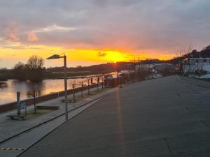 una puesta de sol sobre un río con luz de calle en Hotel Stadt Boizenburg en Boizenburg