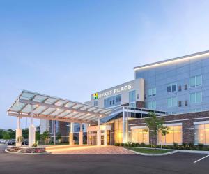 a large building with a parking lot in front of it at Hyatt Place Canton in Lake Cable