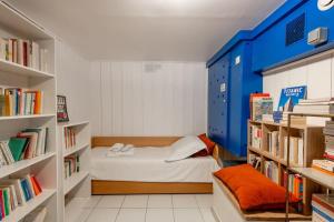 ein kleines Zimmer mit einem Bett und Bücherregalen in der Unterkunft Malakoff - Cosy appartement tout équipé aux portes de Paris in Malakoff