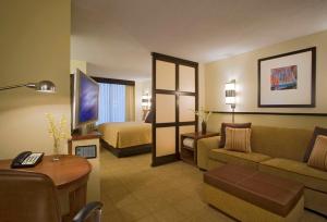 um quarto de hotel com um sofá e uma cama em Hyatt Place North Charleston em Charleston
