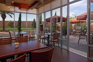 ein Restaurant mit Tischen und Stühlen und großen Fenstern in der Unterkunft Hyatt Place North Charleston in Charleston