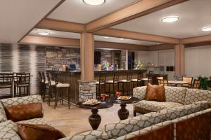 eine Lobby mit Sofas und einer Bar im Hintergrund in der Unterkunft Hyatt House Minot- North Dakota in Minot
