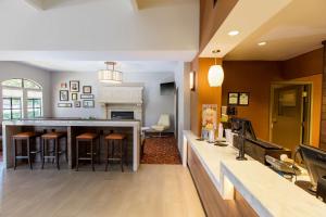 eine Küche und ein Wohnzimmer mit einer Bar mit Hockern in der Unterkunft Hyatt House San Ramon in San Ramon