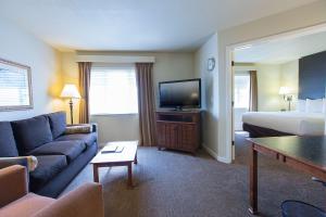 ein Hotelzimmer mit einem Sofa, einem Bett und einem TV in der Unterkunft Hyatt House San Ramon in San Ramon