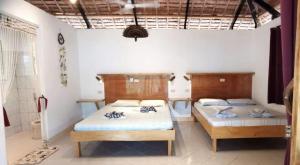 NauhangにあるSulu Sunset Beach Resortのベッドルーム1室(ベッド2台付)、バスルーム(シャワー付)が備わります。