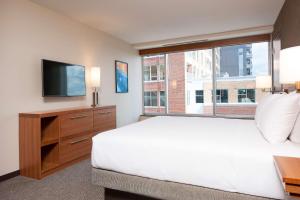 Un dormitorio con una cama grande y una ventana en Hyatt Place Champaign/Urbana, en Champaign