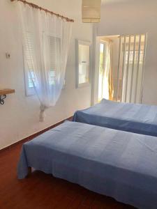 a bedroom with two beds and a window at Studios on the beach in Galaxidi