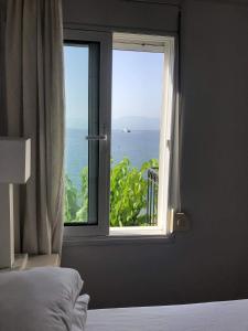a bedroom with a window with a view of the ocean at Studios on the beach in Galaxidi