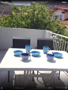 a white table with blue bowls on top of it at Studios on the beach in Galaxidi