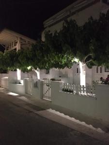 a white fence in front of a house at night at Studios on the beach in Galaxidi