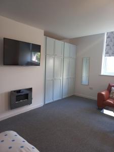 a living room with a flat screen tv and a couch at Sea Breeze Studio @ The Coach House in Saint Annes on the Sea