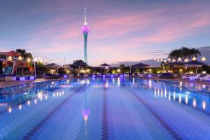 une piscine avec une tour en arrière-plan dans l'établissement Hilton Colombo Residence, à Colombo