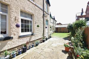 a courtyard of a house with potted plants at Sea Breeze Studio @ The Coach House in Saint Annes on the Sea