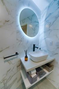 Baño blanco con lavabo y espejo en Apartemanto Luxury vistas Nqn 1 bed en Neuquén