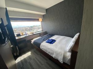 Un dormitorio con una cama con una toalla azul. en Tsukino HOTEL en Sakata