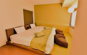a bedroom with a large bed and a chair at Tsukino HOTEL in Sakata